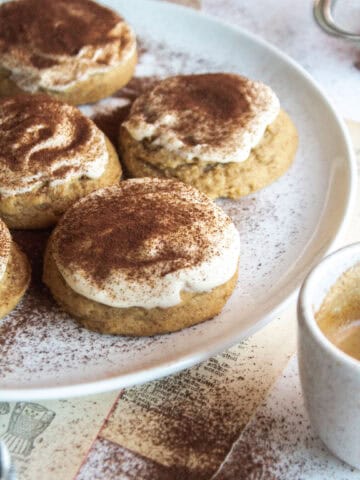 Angle of a tiramisu cookie with mascarpone icing and espresso powder on top.
