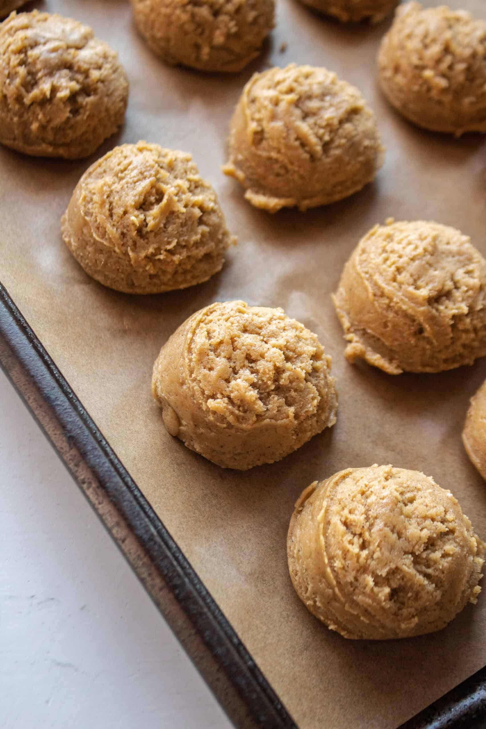 Balls of cookie dough on a baking sheet.