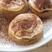 Angle of a tiramisu cookie with mascarpone icing and espresso powder on top.