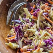 close up of a portion of a cabbage crunch salad in a wooden bowl.