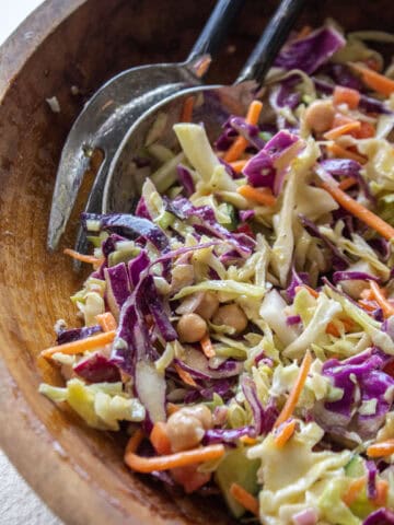 close up of a portion of a cabbage crunch salad in a wooden bowl.
