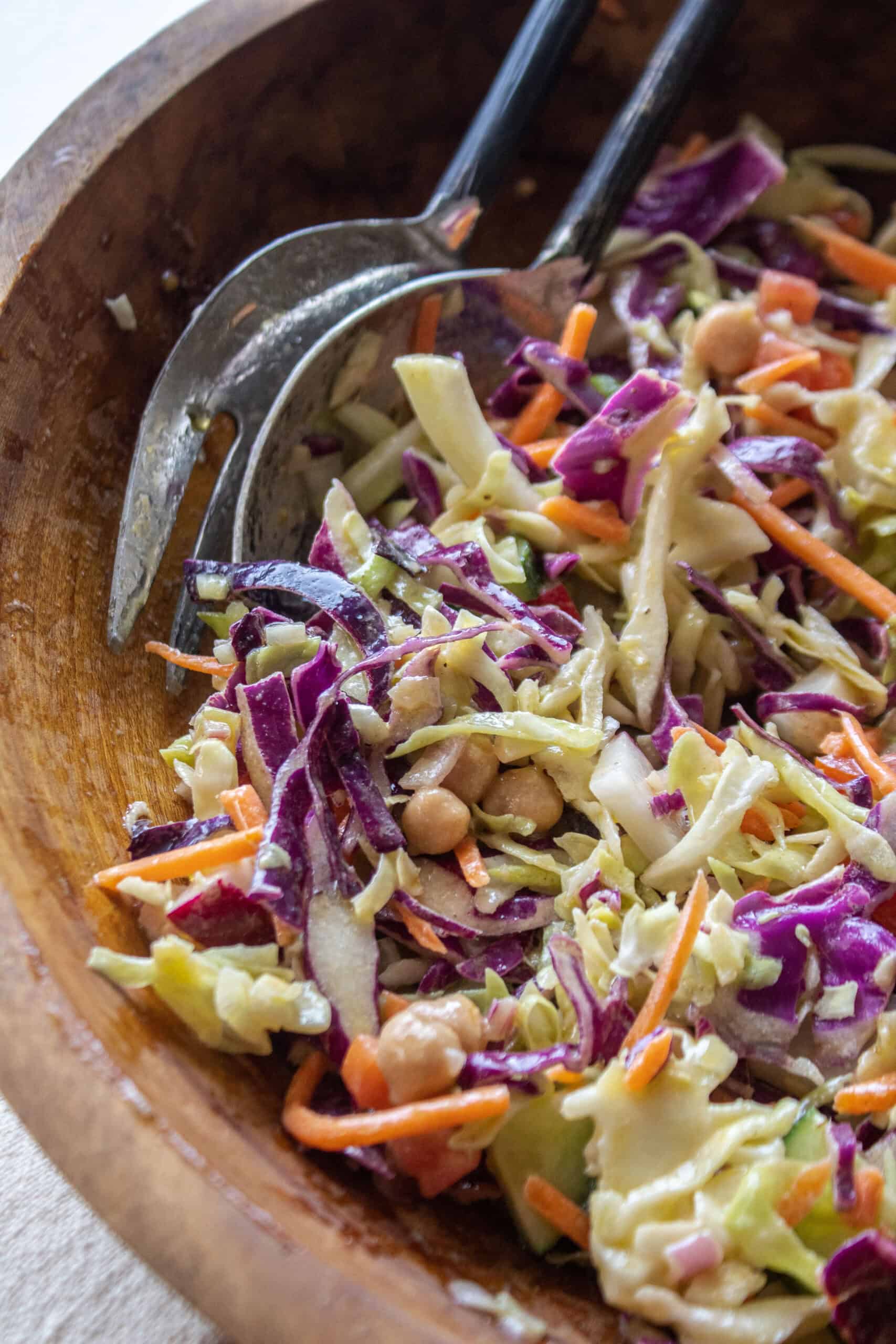 close up of a portion of a cabbage crunch salad in a wooden bowl.