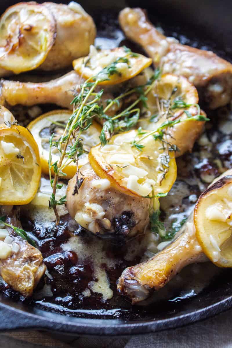 close up of a piece of chicken with lemon and thyme.