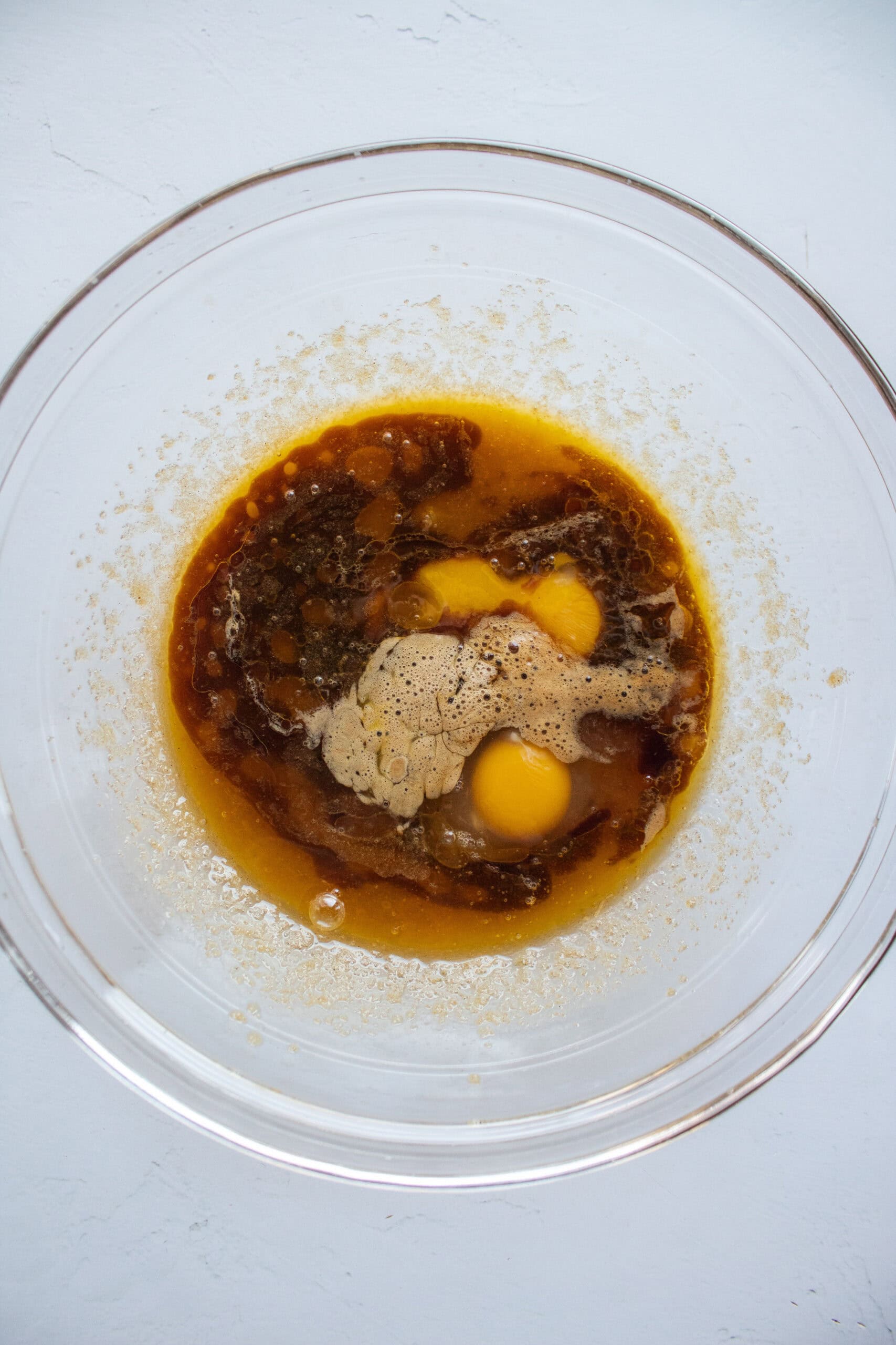 Egg and egg yolk and cold espresso added to a bowl.