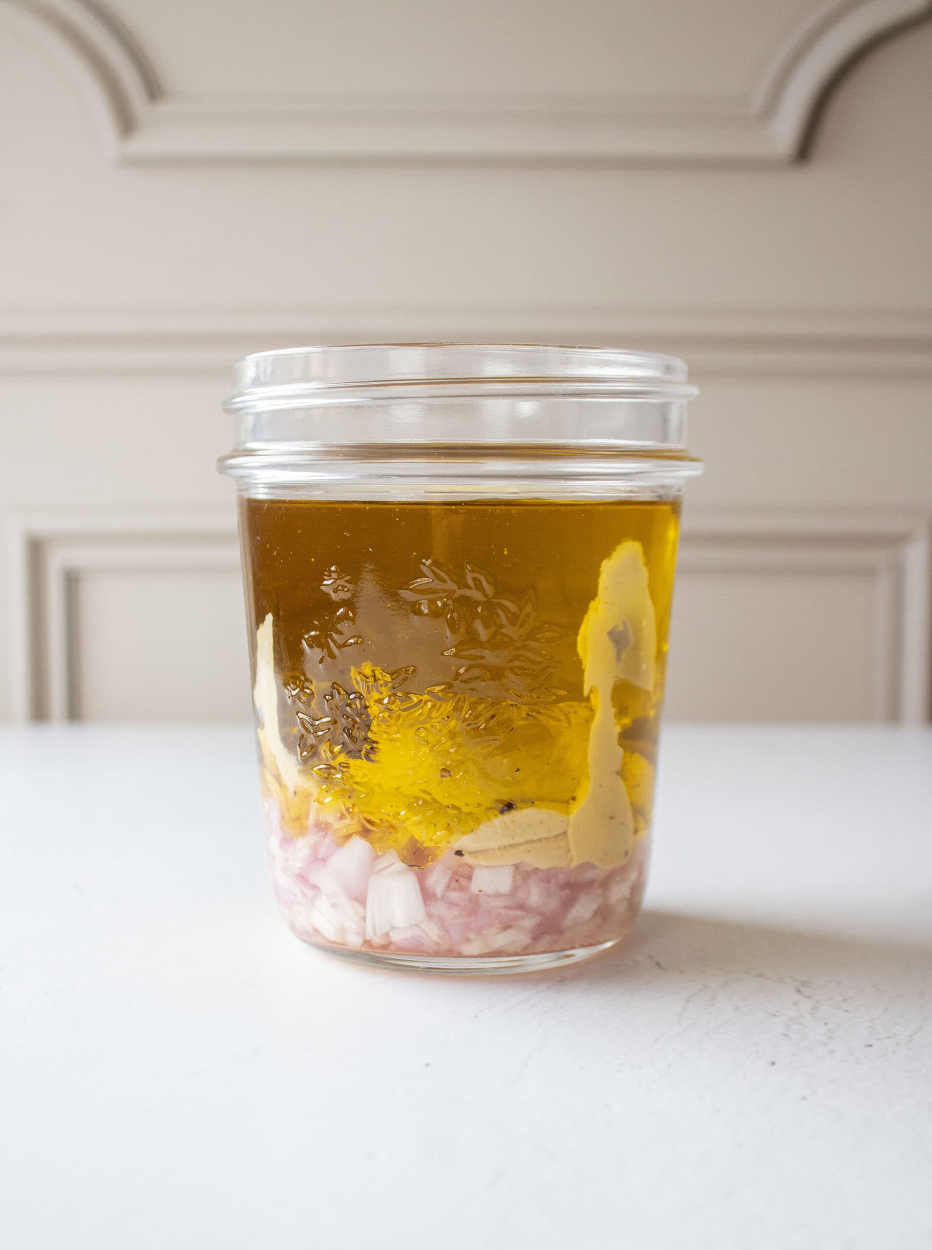 shallot, dijon mustard, olive oil, and white wine vinegar added to a mason jar.