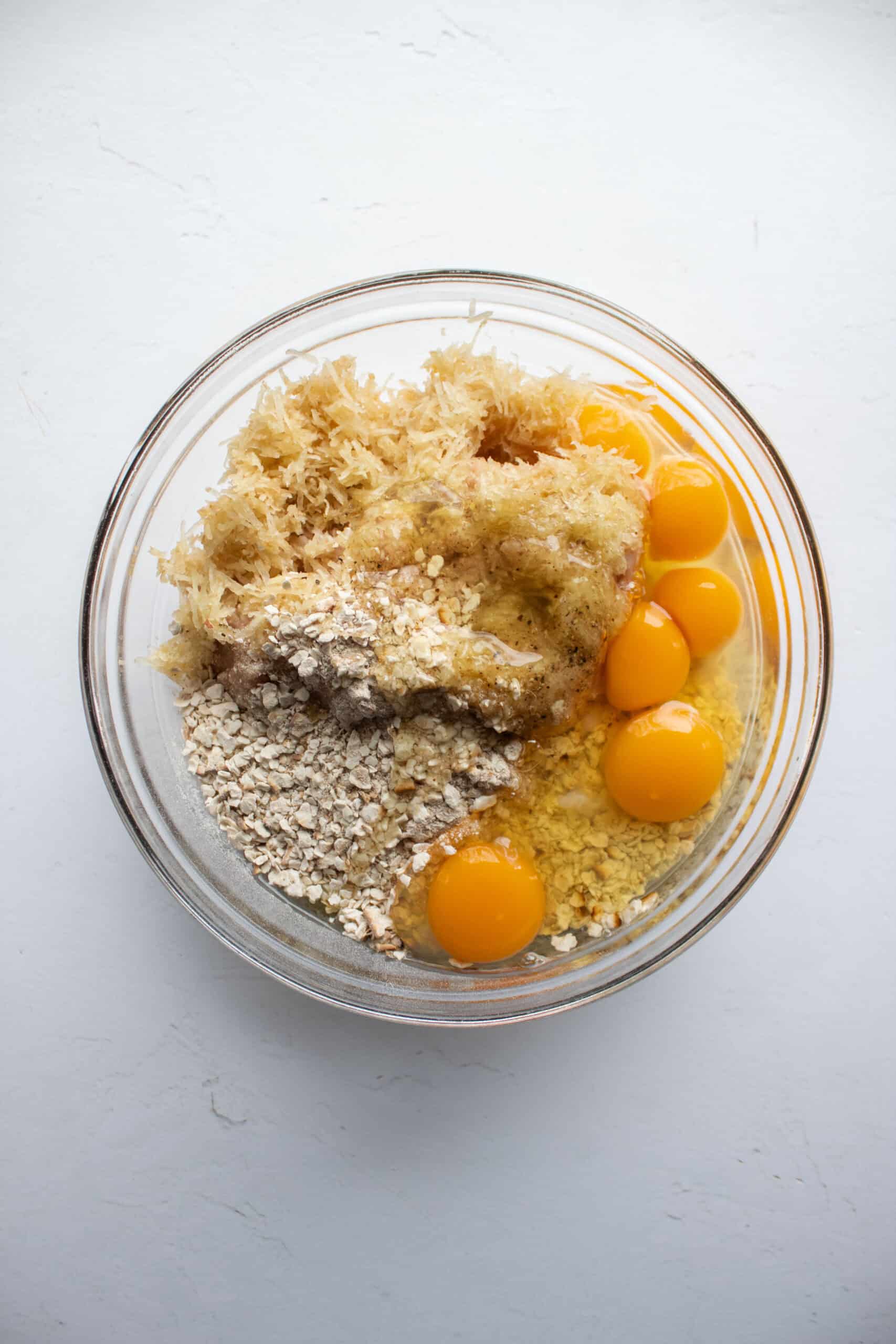 Eggs, ground chicken, parsnip, and matzo meal in a large mixing bowl.