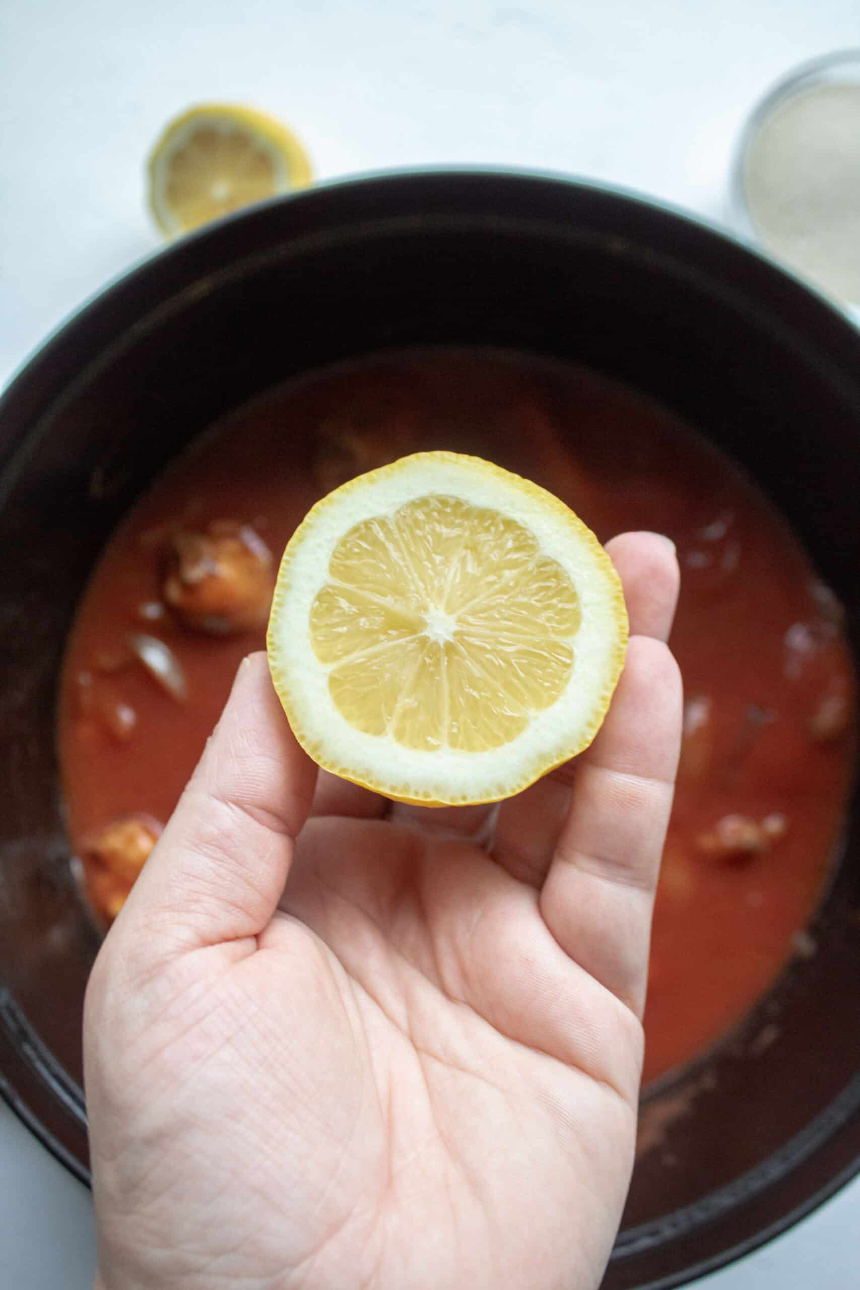 Lemon being added to a dutch oven.