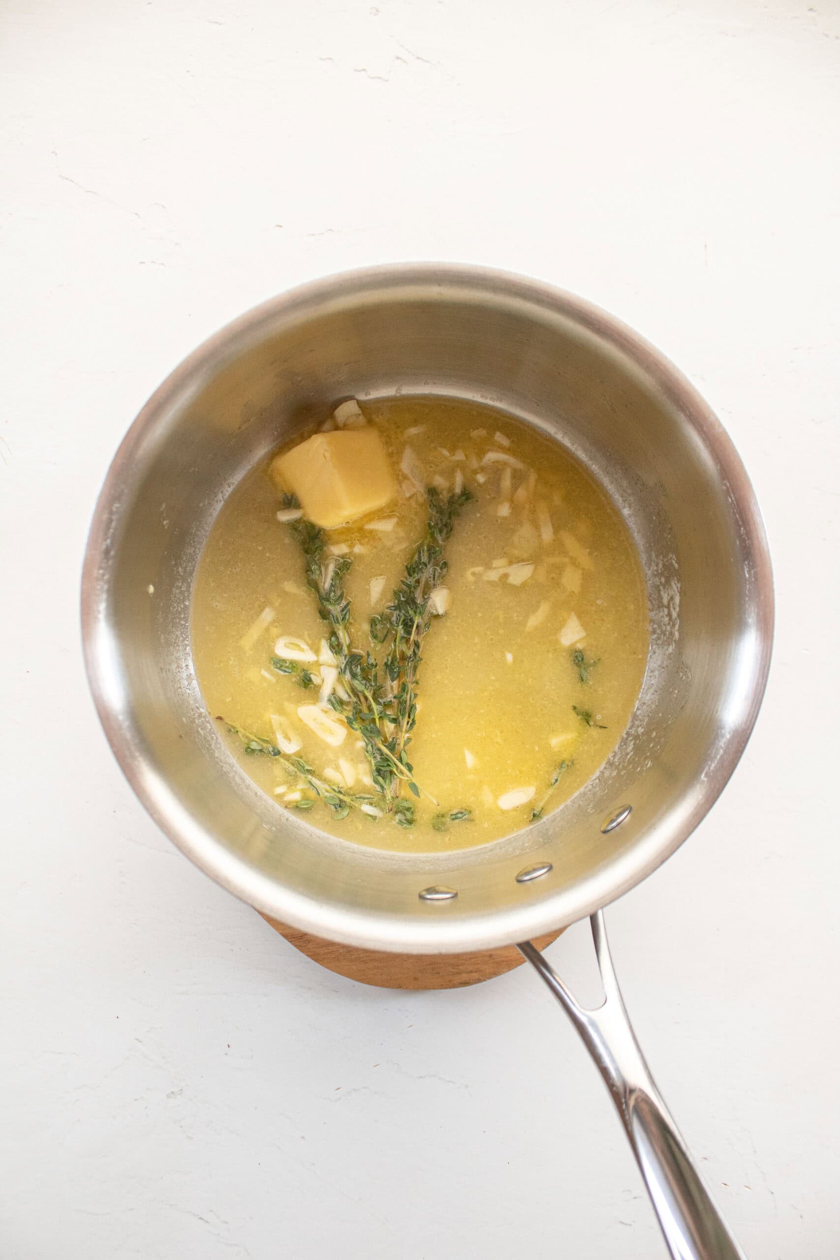 melted butter with garlic, lemon, white wine, and thyme in a small saucepan.