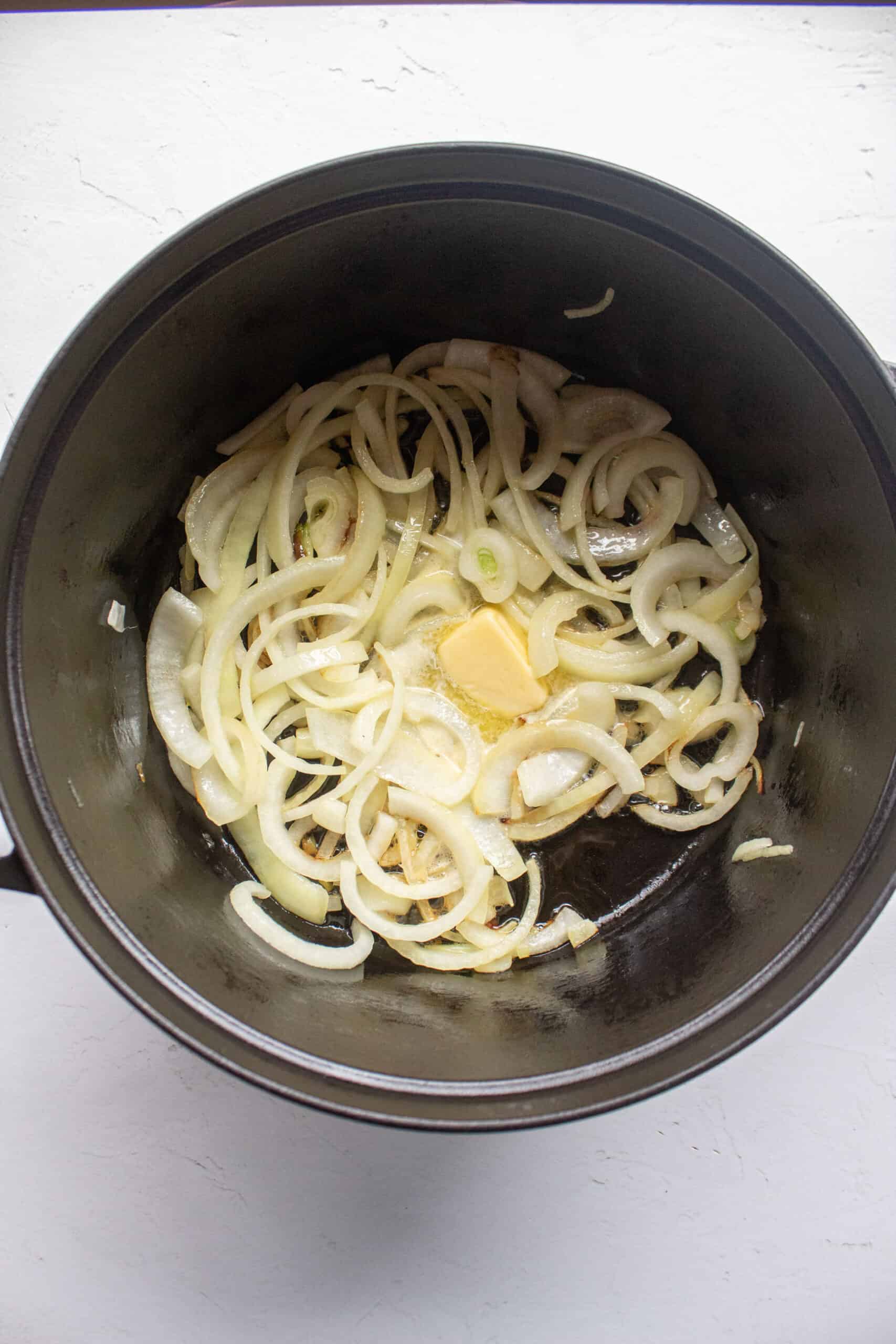Butter, oil, and onions added to a dutch oven.