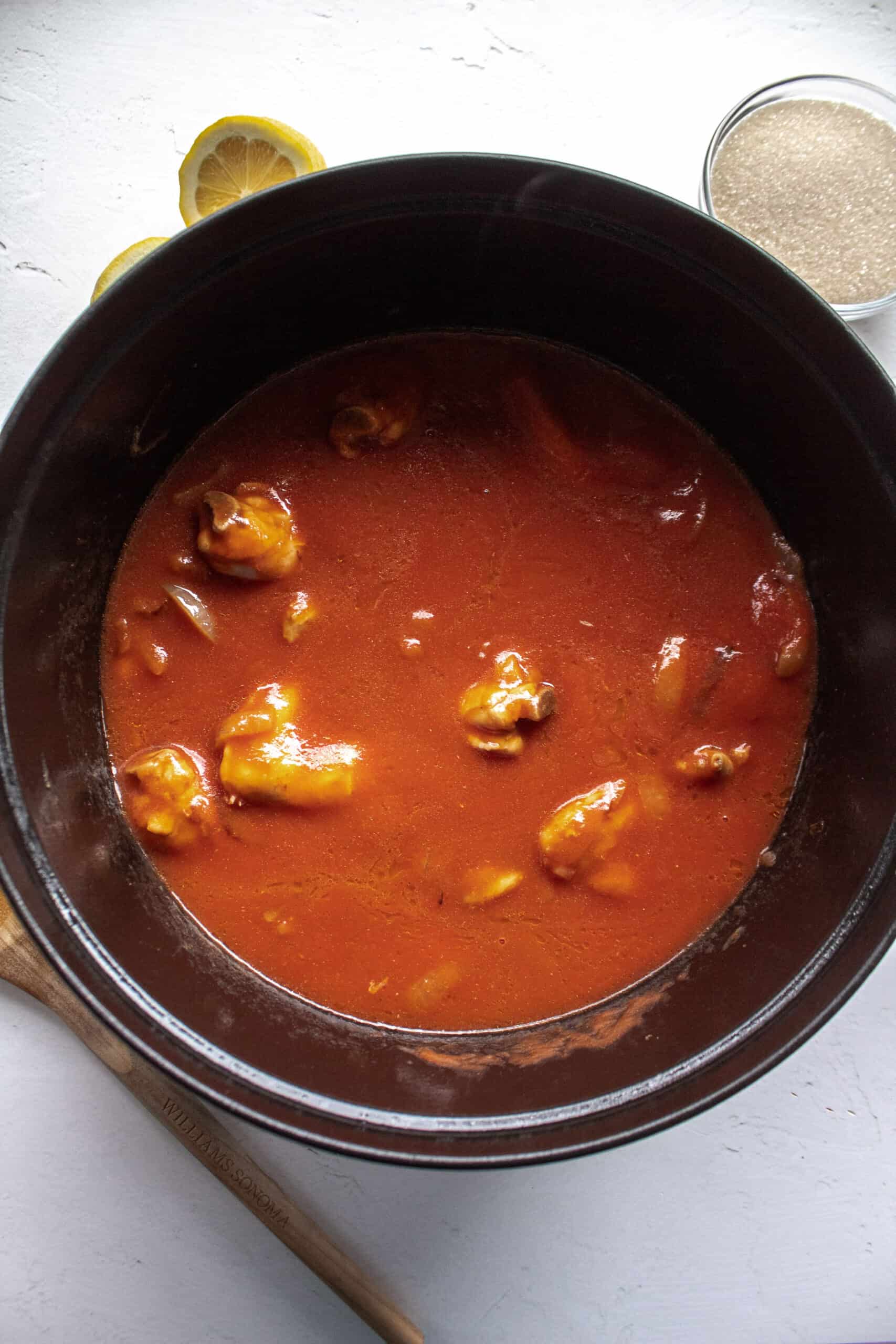 Tomato sauce added to chicken wings browned with onions