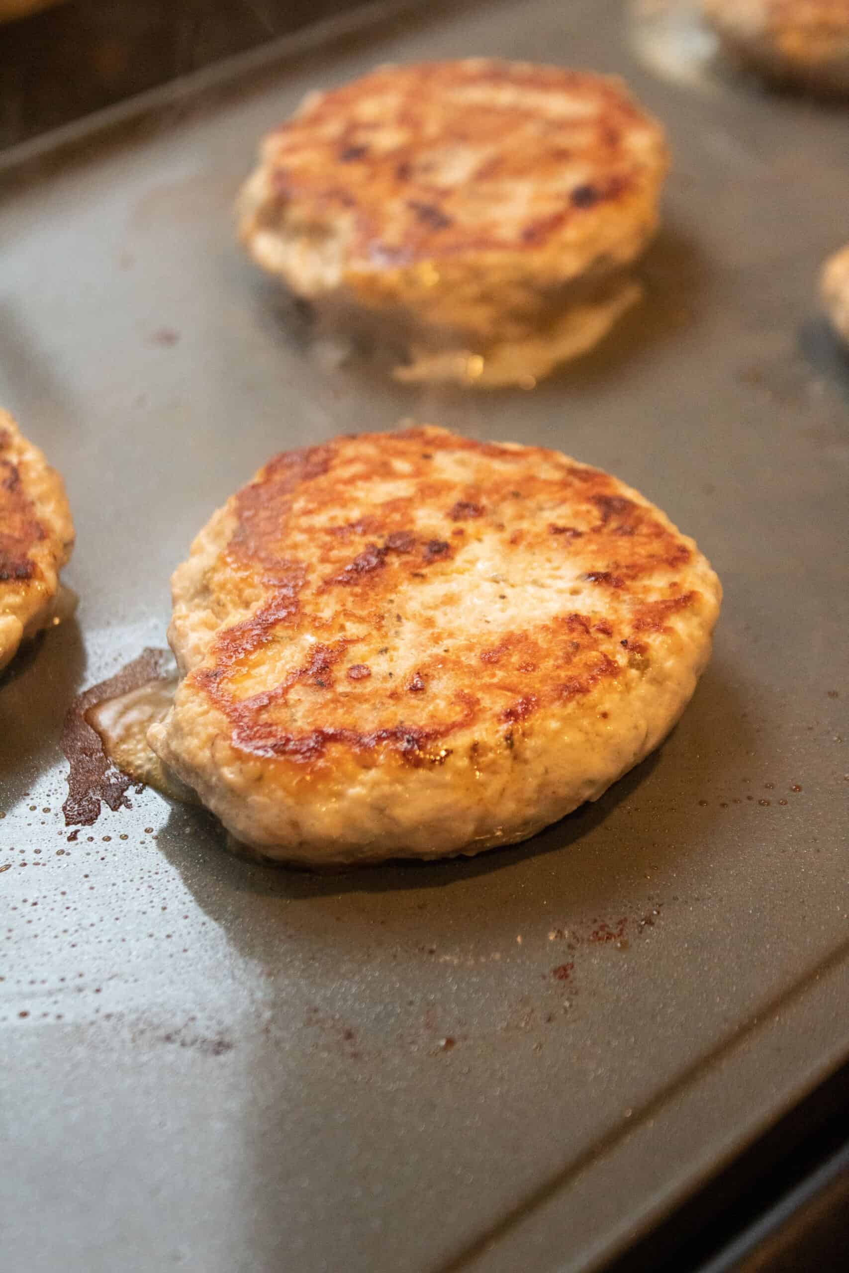 a cooked chicken burger on an electric griddle.