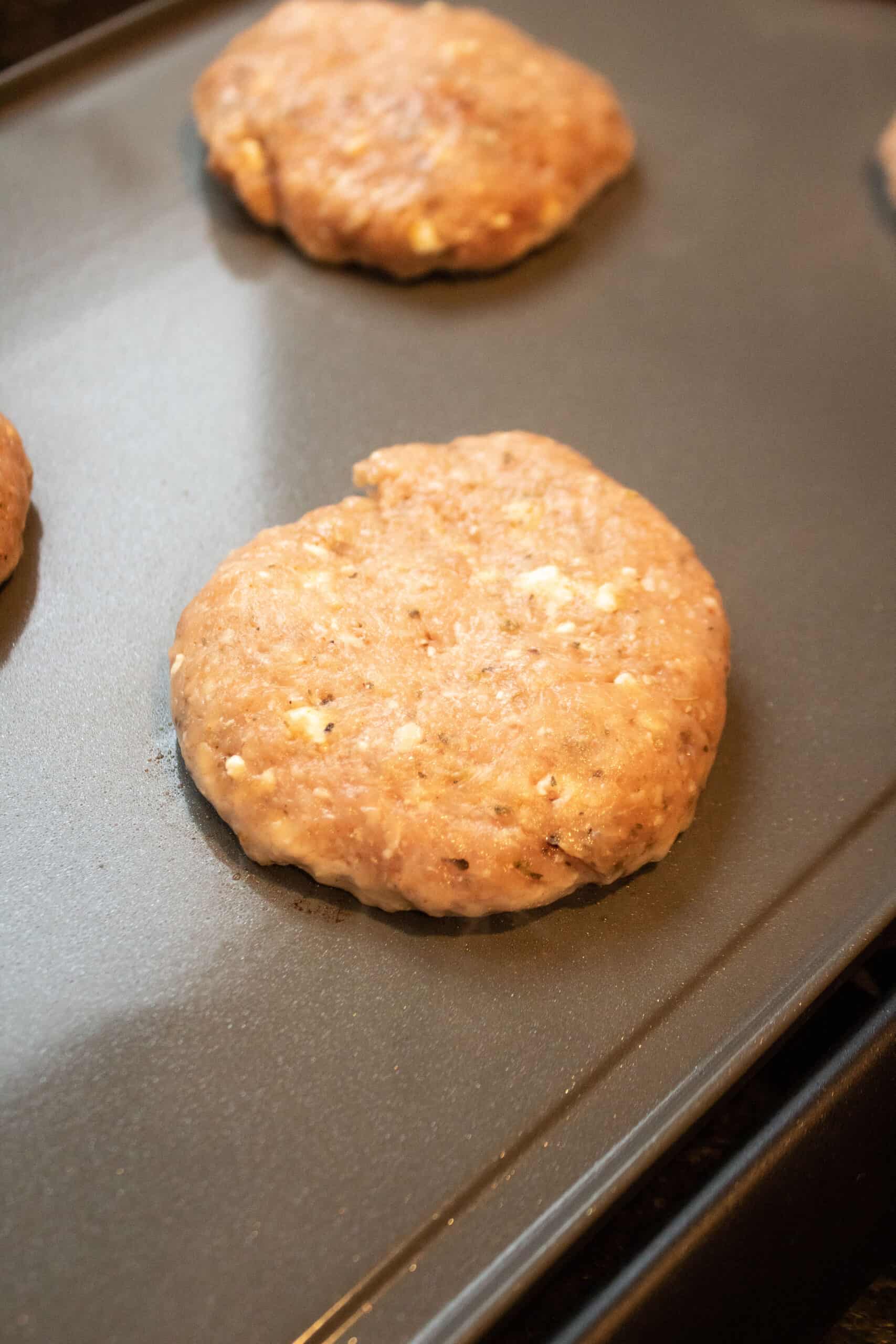 a chicken burger on an electric griddle.