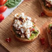close up of bruschetta crostini topped with with burrata and balsamic glaze.