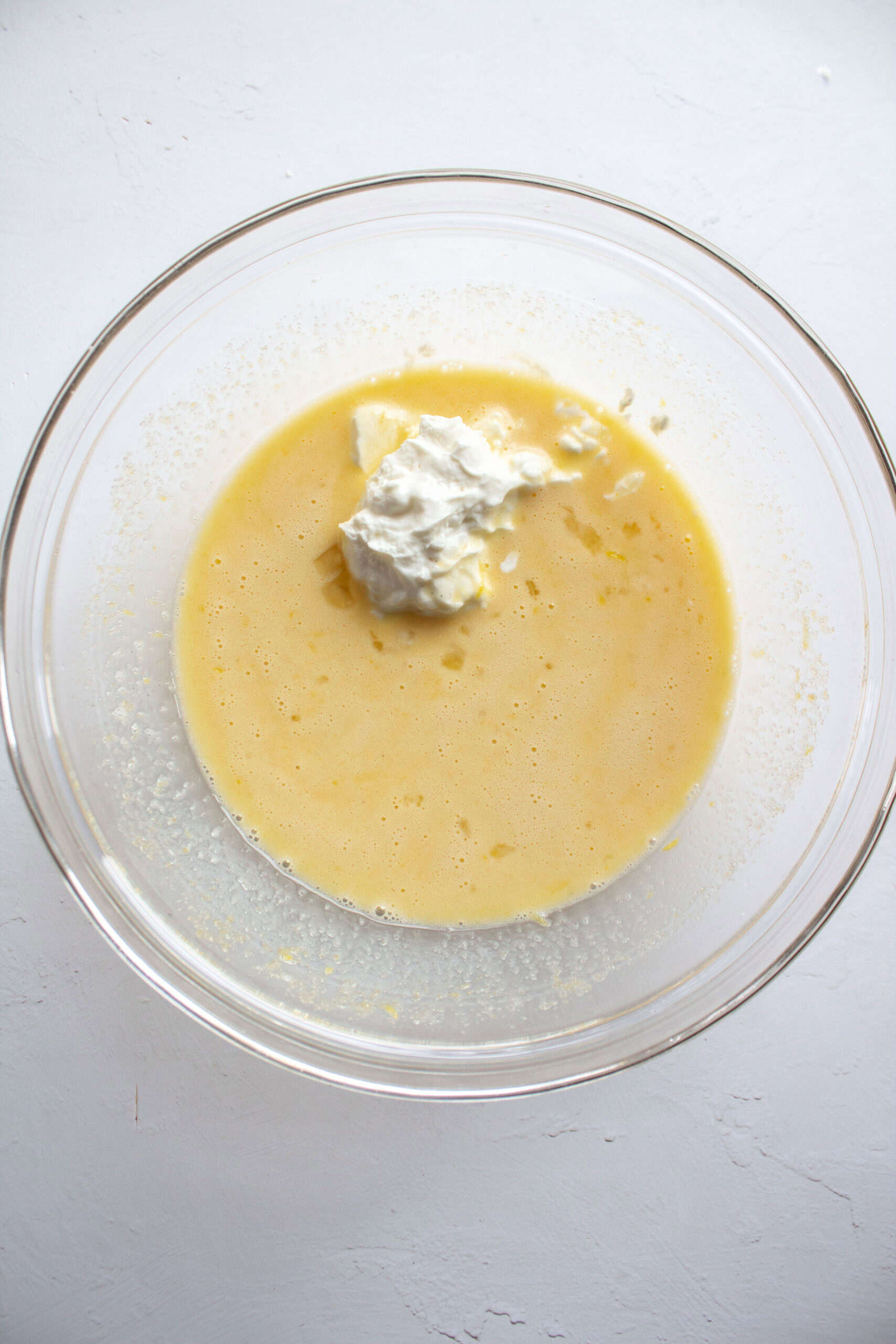 a bowl of cake batter with a scoop of greek yogurt in it.