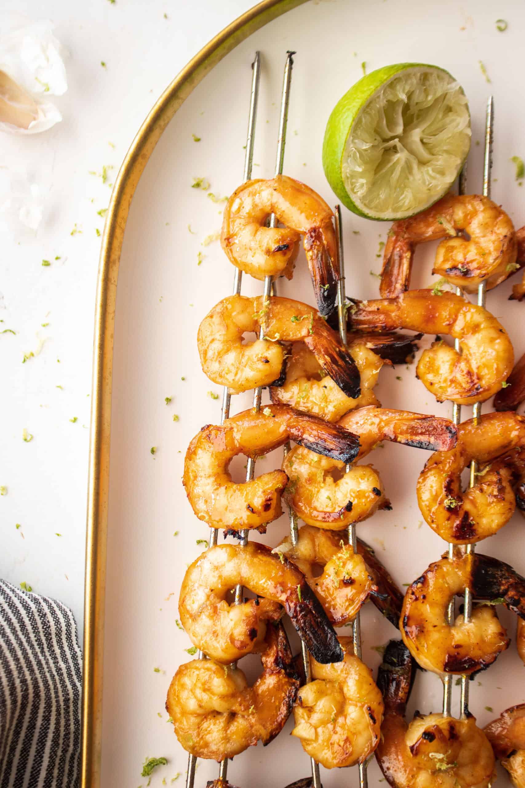 shrimp skewers on a plate with lime.