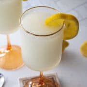 Frozen french 75 ink a tall glass with a lemon wedge.