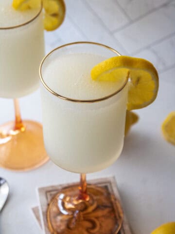 Frozen french 75 ink a tall glass with a lemon wedge.