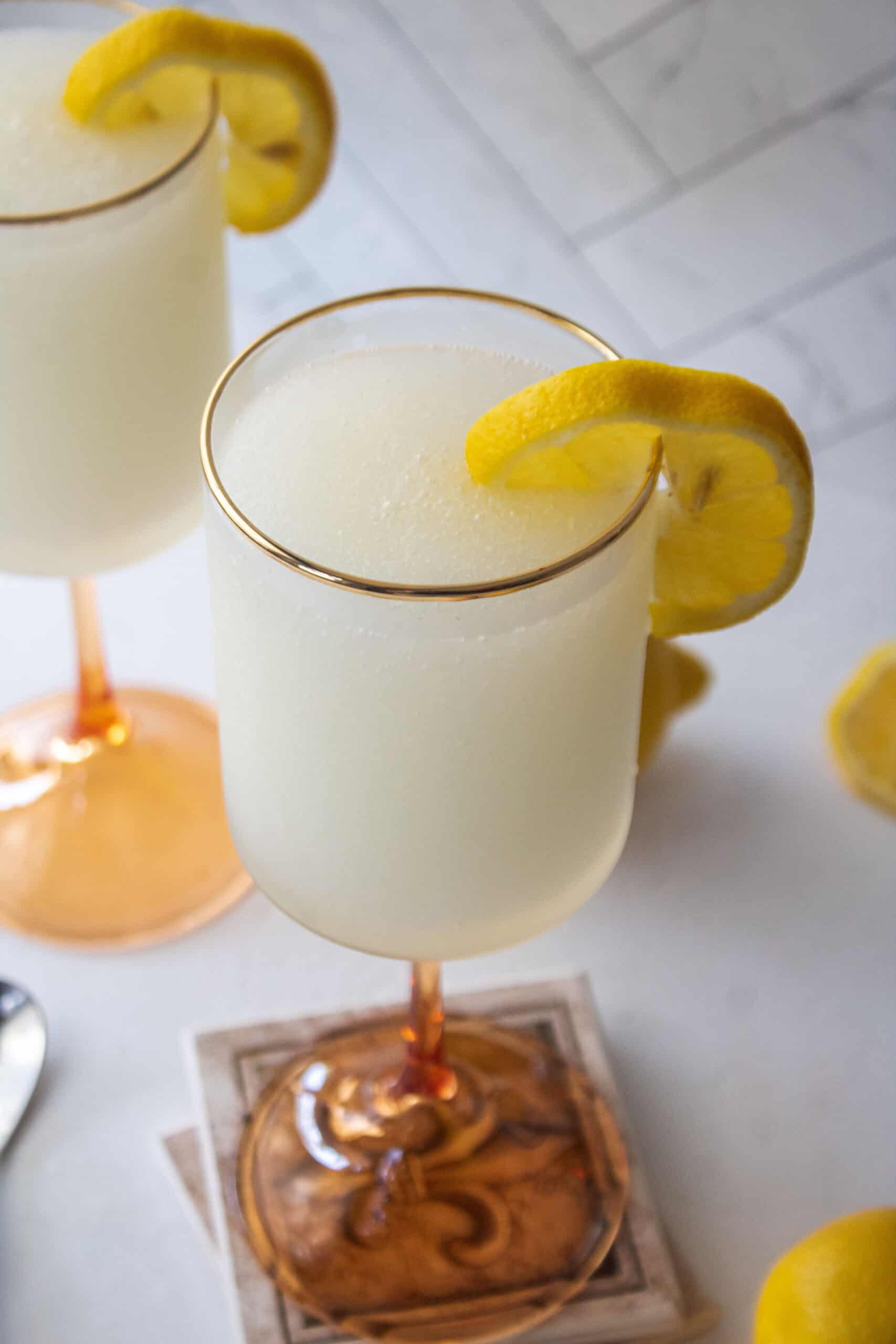 Frozen french 75 ink a tall glass with a lemon wedge.