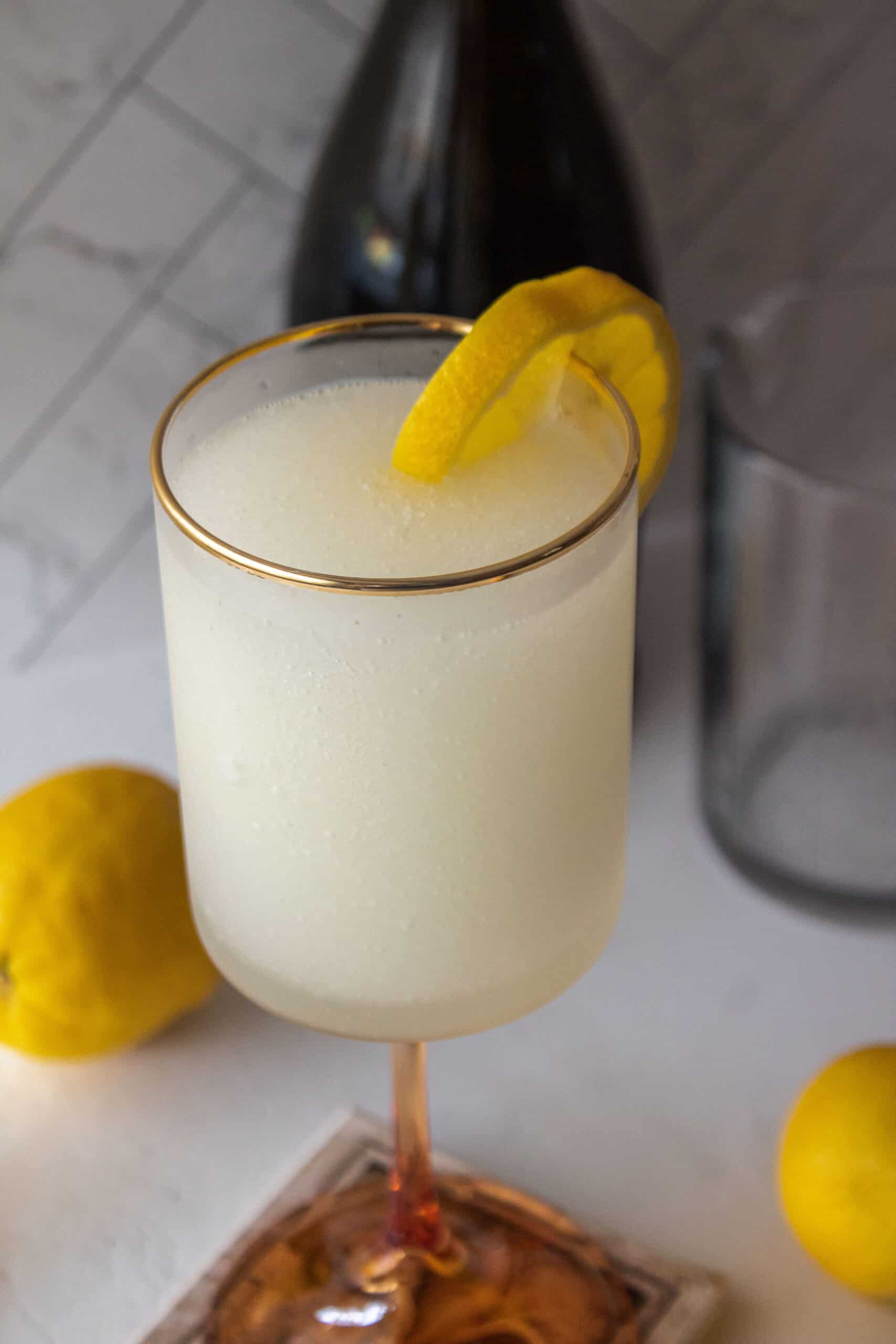 Frozen french 75 ink a tall glass with a lemon wedge.