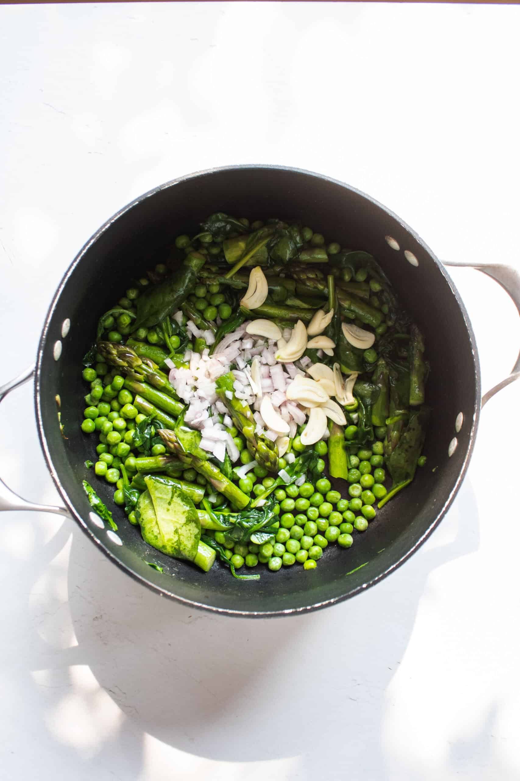 Sauteed vegetables in a pot with shallot and garlic.