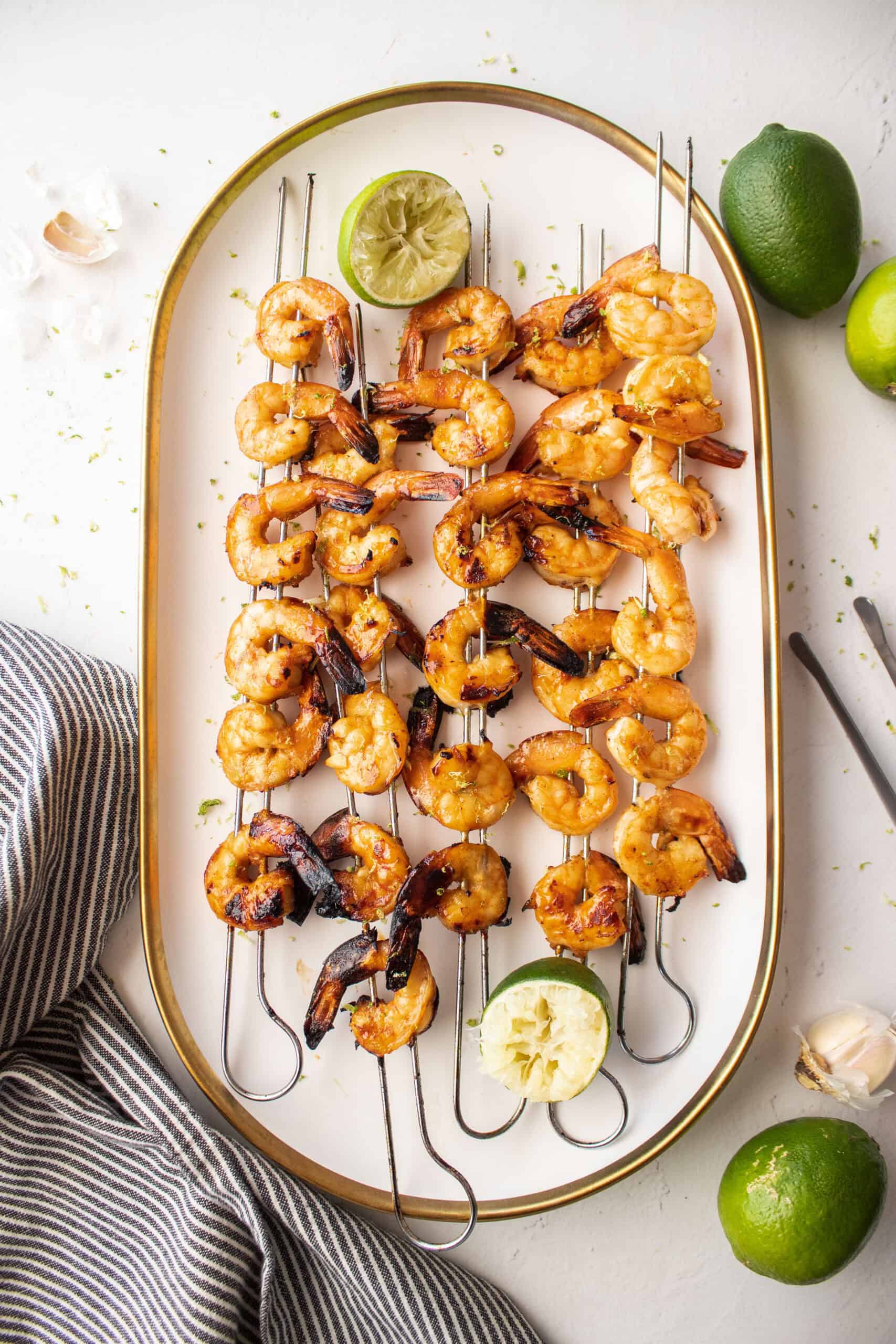 shrimp skewers on a plate with lime.