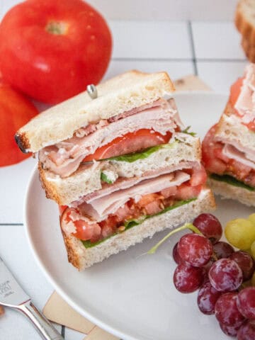 A turkey club sandwich on a plate.
