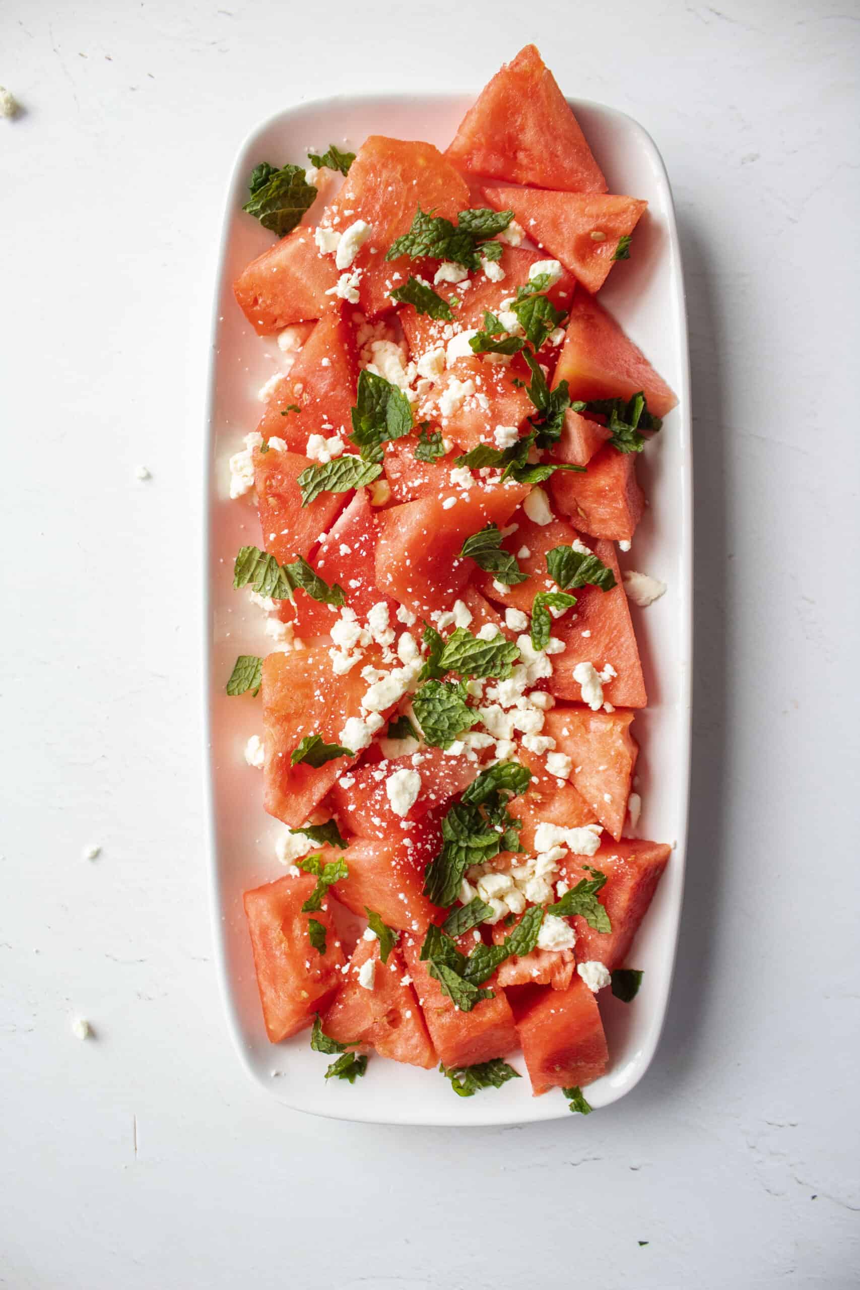 Watermelon on a plate with feta and mint.