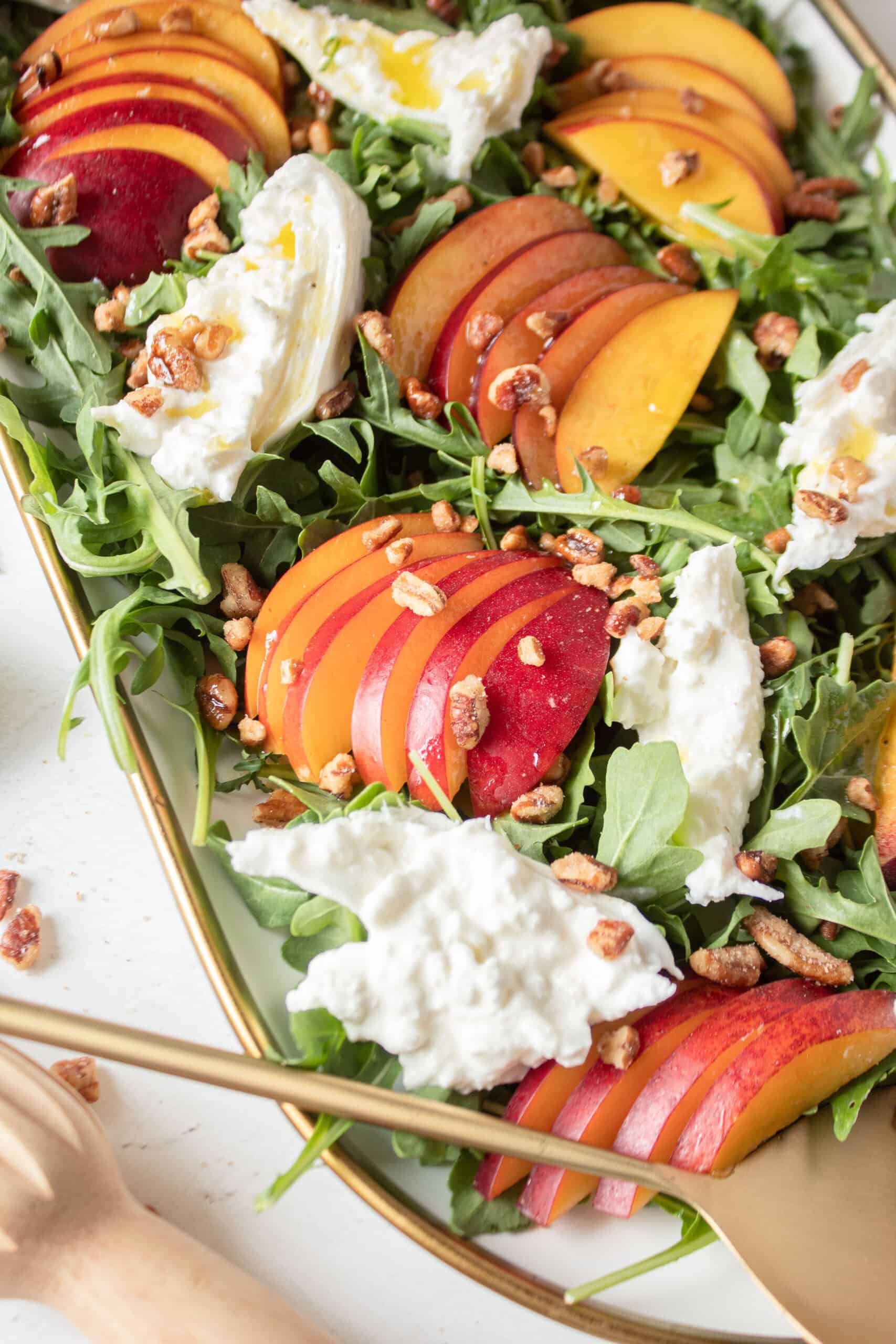 close up of nectarines and burrata on a bed of arugula.