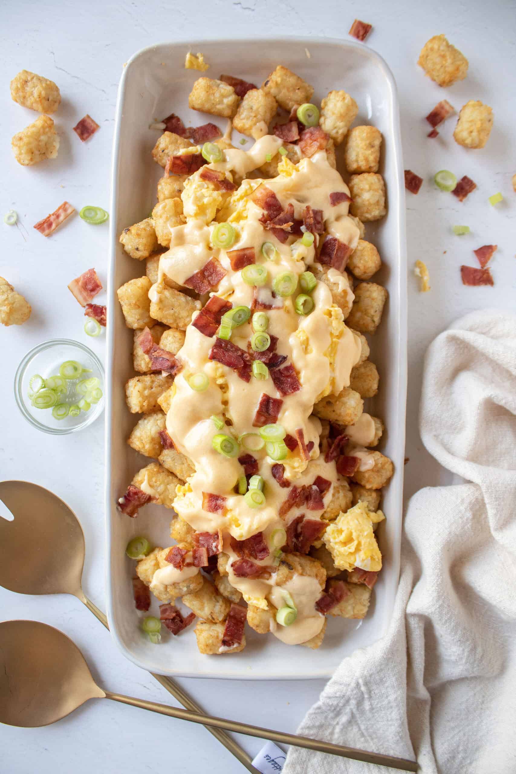 Loaded breakfast totchos with bacon, scallions, eggs, cheese.