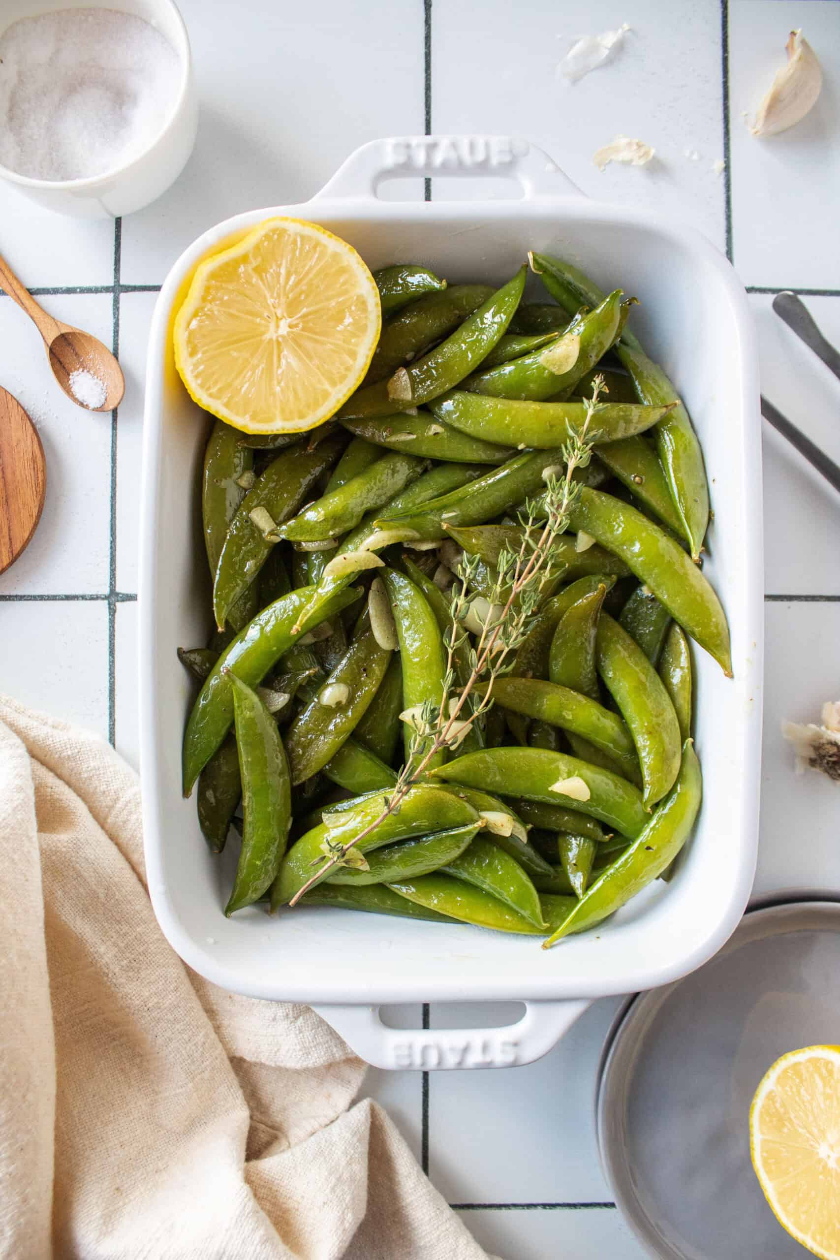 Sautéed sugar snap peas in a dish with garlic, lemon, and thyme.
