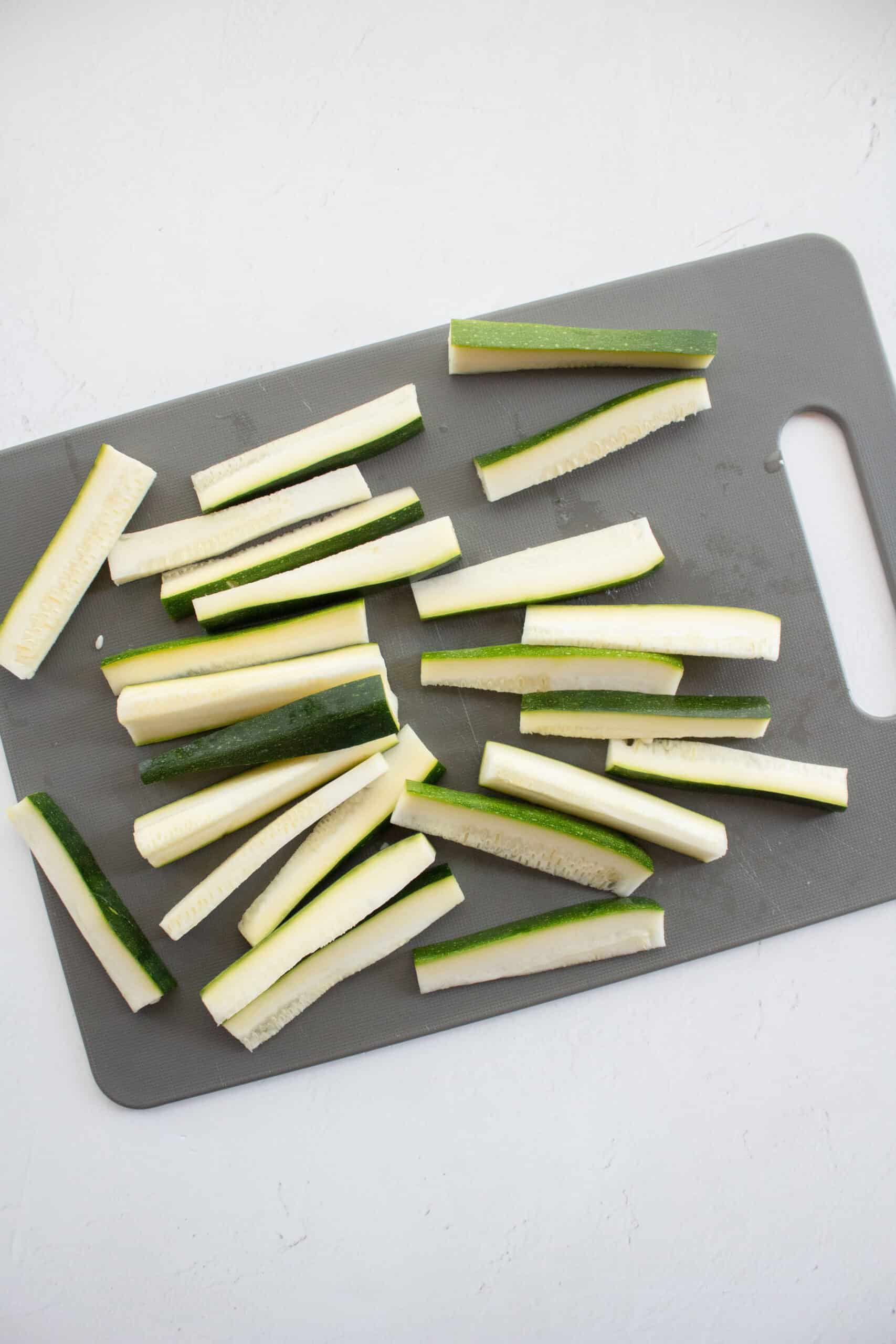 Sliced zucchini on a cutting board.
