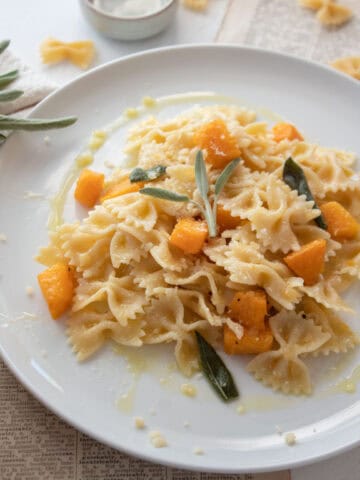 Butternut squash pasta on a plate with butter and sage sauce.