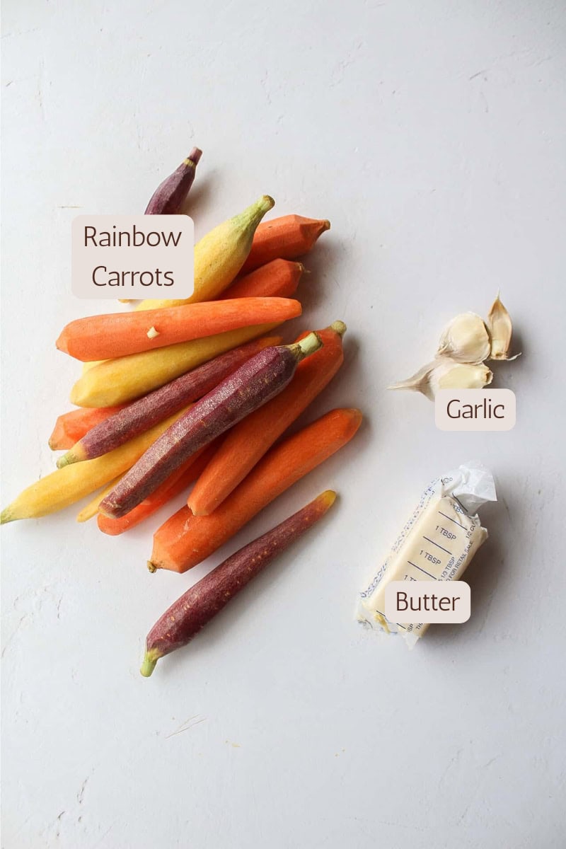 Ingredients needed to make garlic butter roasted rainbow carrots.