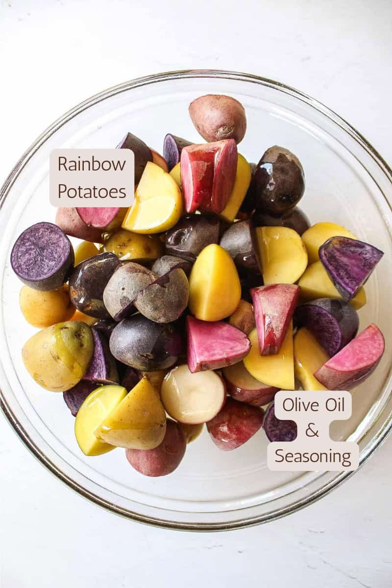 Ingredients needed to make crispy herb roasted rainbow potatoes in a bowl.