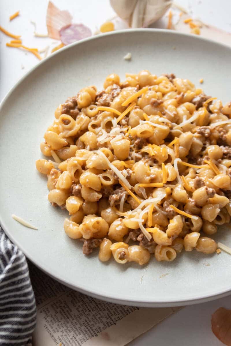 One pot cheeseburger pasta on a plate with cheese and dried pasta around it.