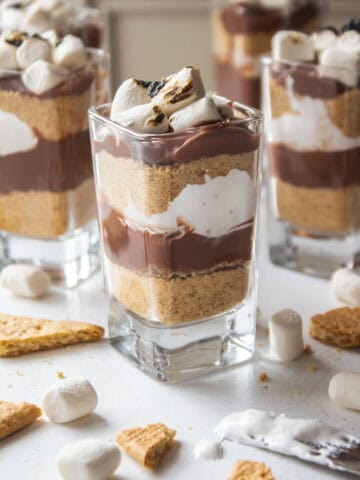Smores parfaits with graham crackers, pudding, marshmallow cream, topped with toasted marshmallows.