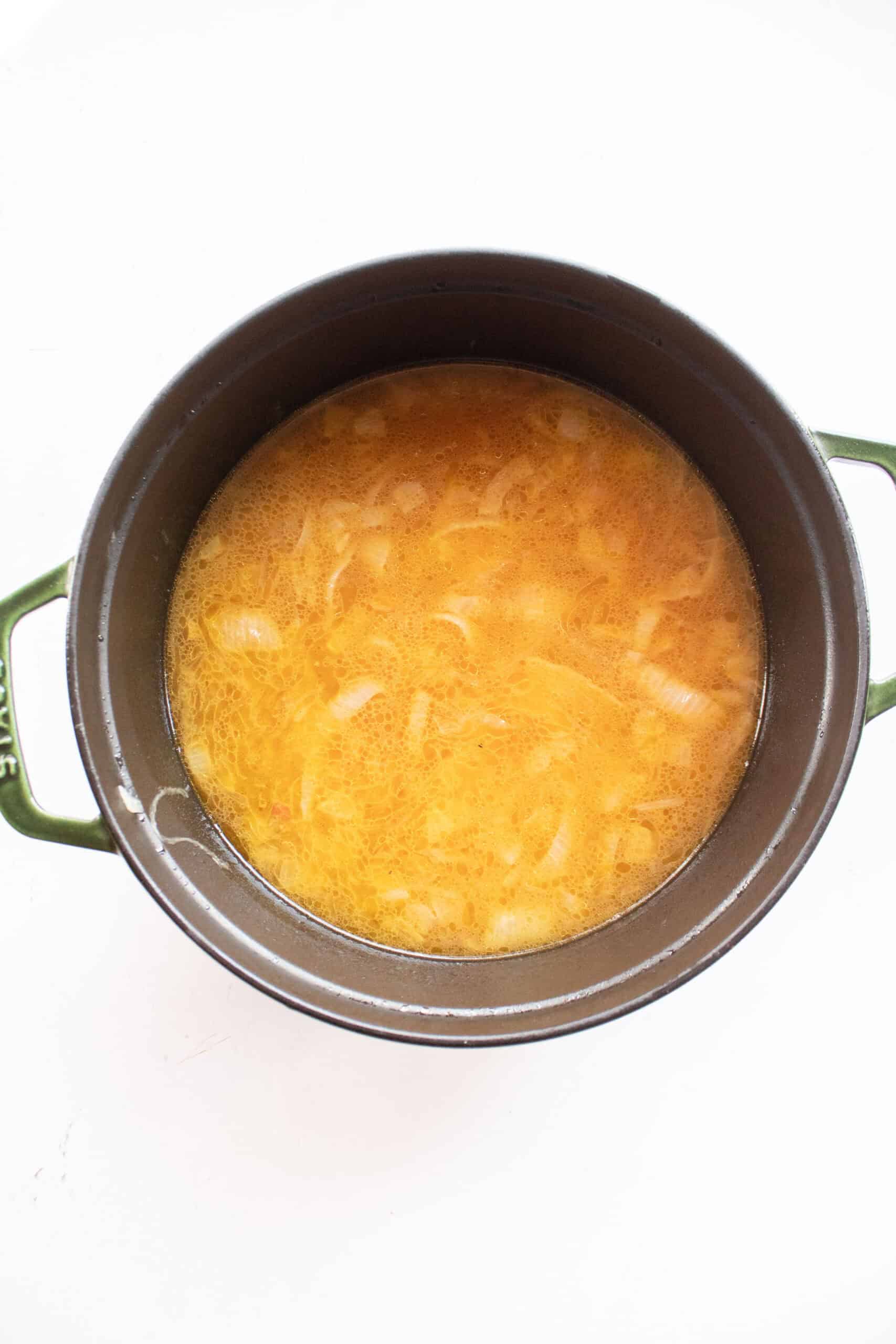 Caramelized onions and beef broth in a dutch oven.