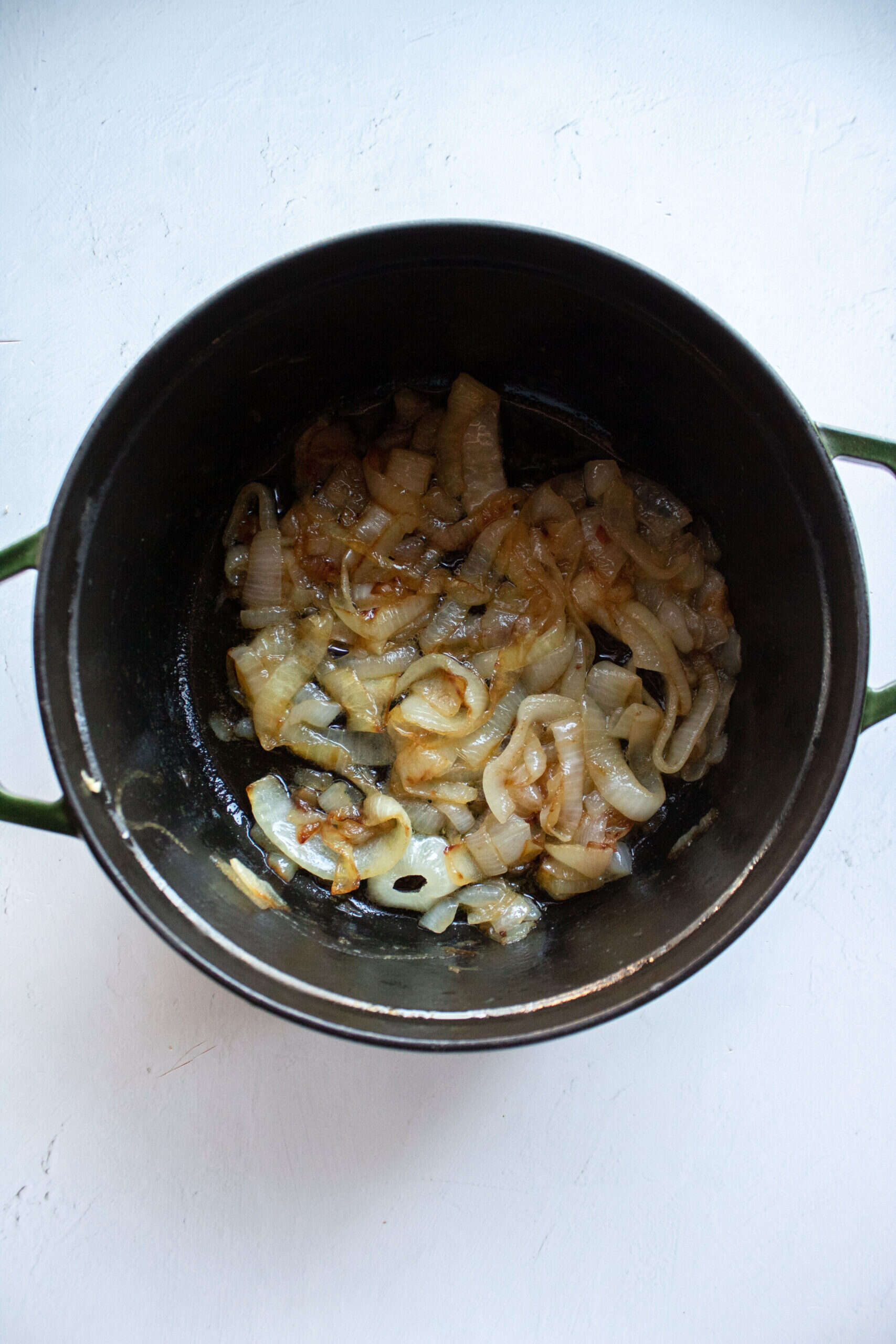 Caramelized onions cooking for 40 minutes in the dutch oven on the stove.