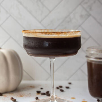 Pumpkin spice espresso martini cocktail in a rimmed coupe glass with pumpkin pie spice.