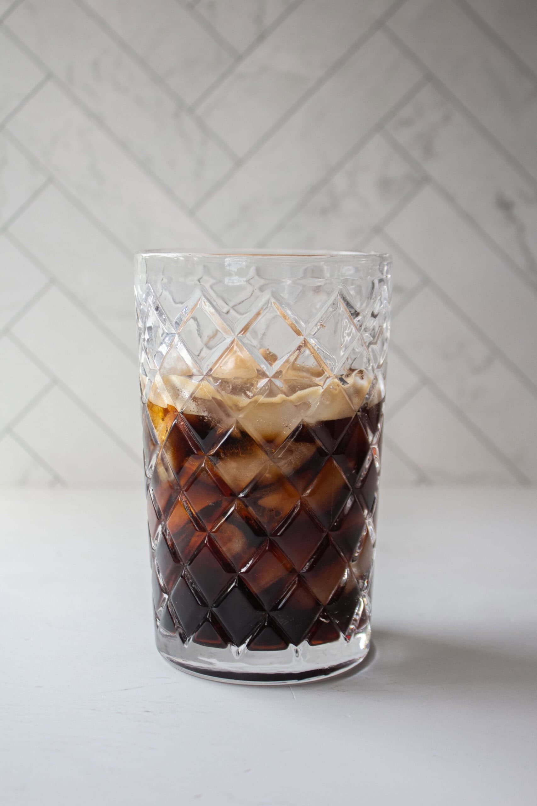 Espresso, coffee liqueur, ice, and vodka in a glass shaker.