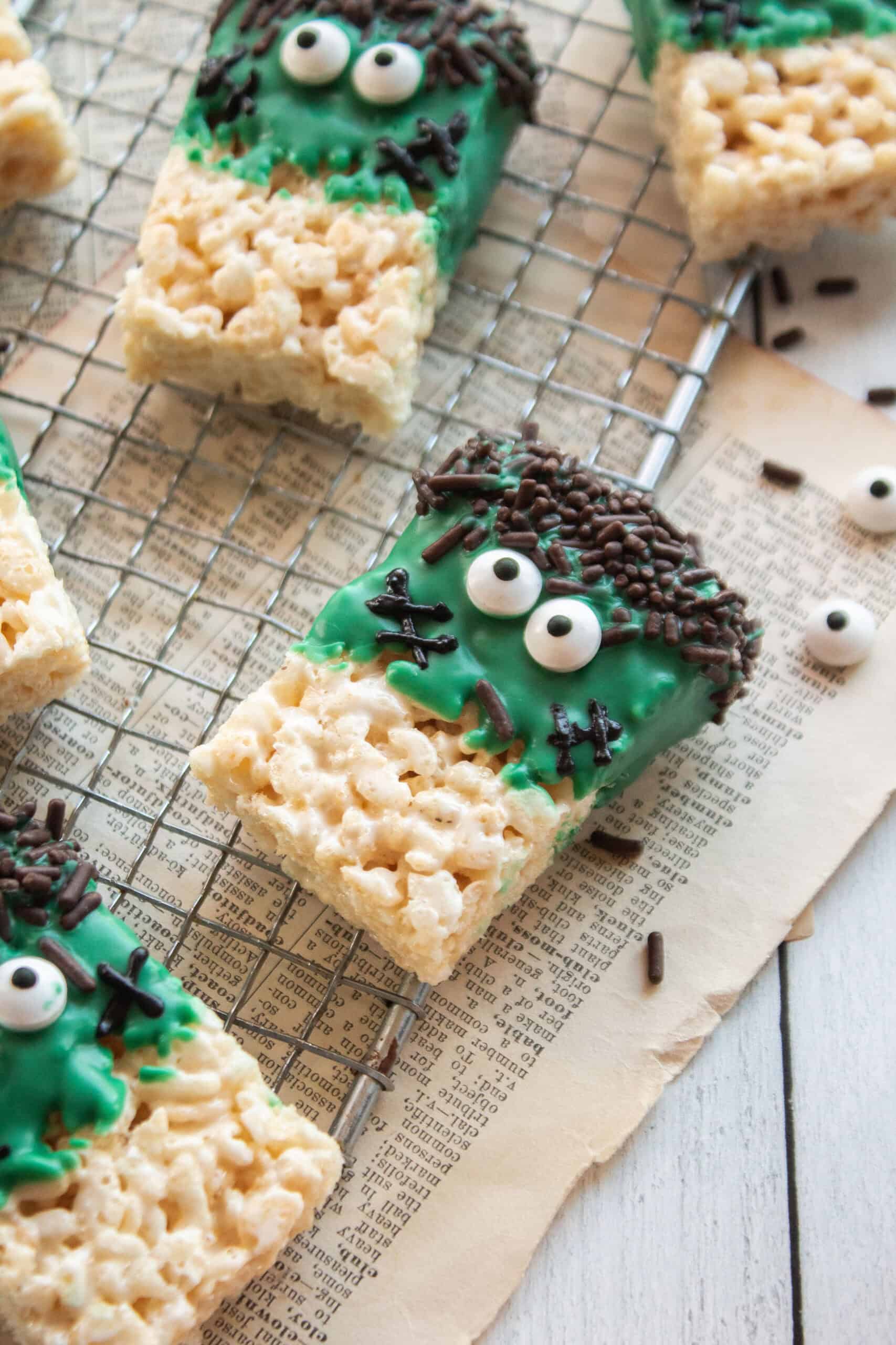 A closeup of a frankenstein rice krispie treat on a cooling rack.