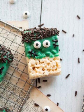 A closeup of a frankenstein rice krispie treat on a cooling rack.