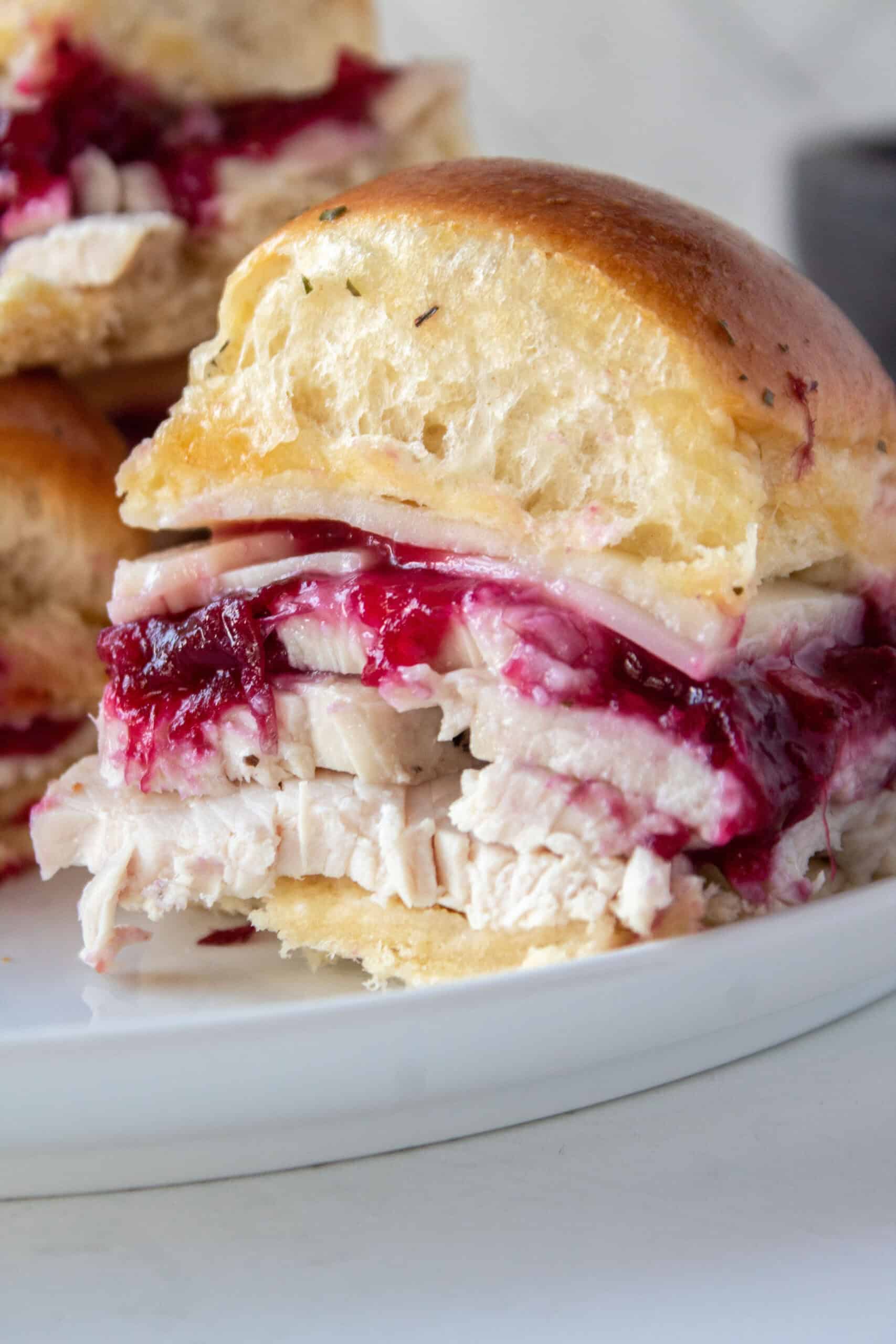 Close up of a turkey cranberry slider on a white plate.