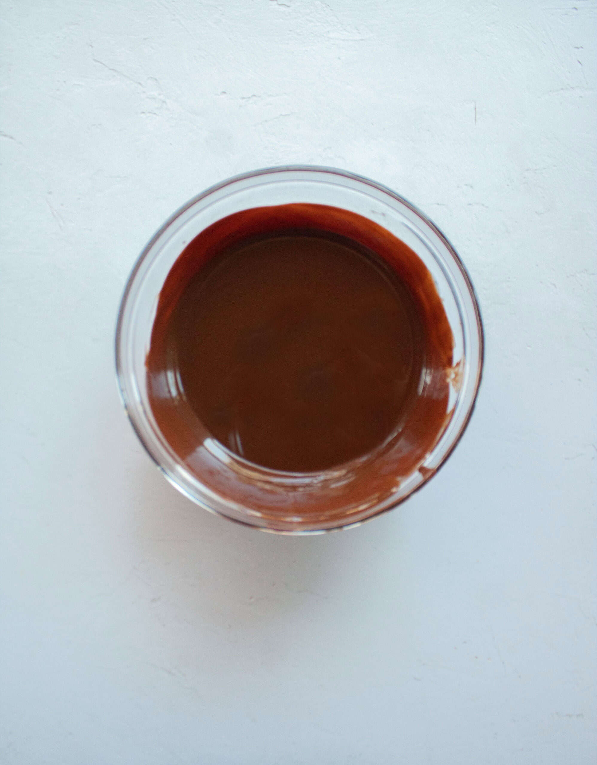 Melted chocolate in a medium glass bowl.