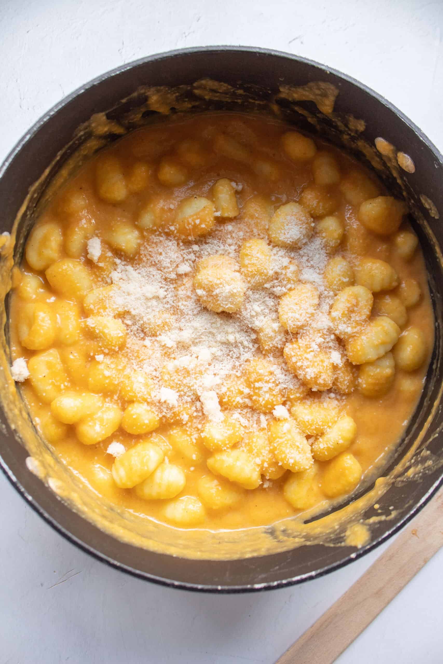 Gnocchi mixed with butternut squash pasta sauce with parmesan cheese sprinkled on top.