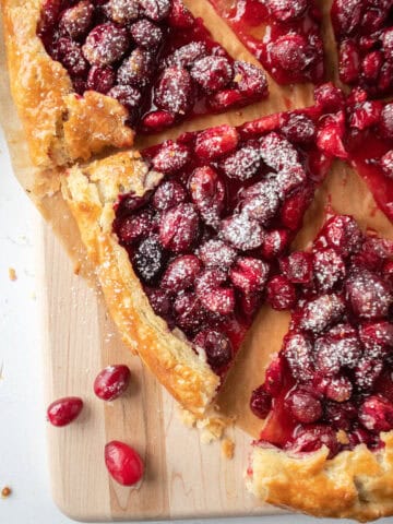 A slice of a cranberry orange galette on a serving board.
