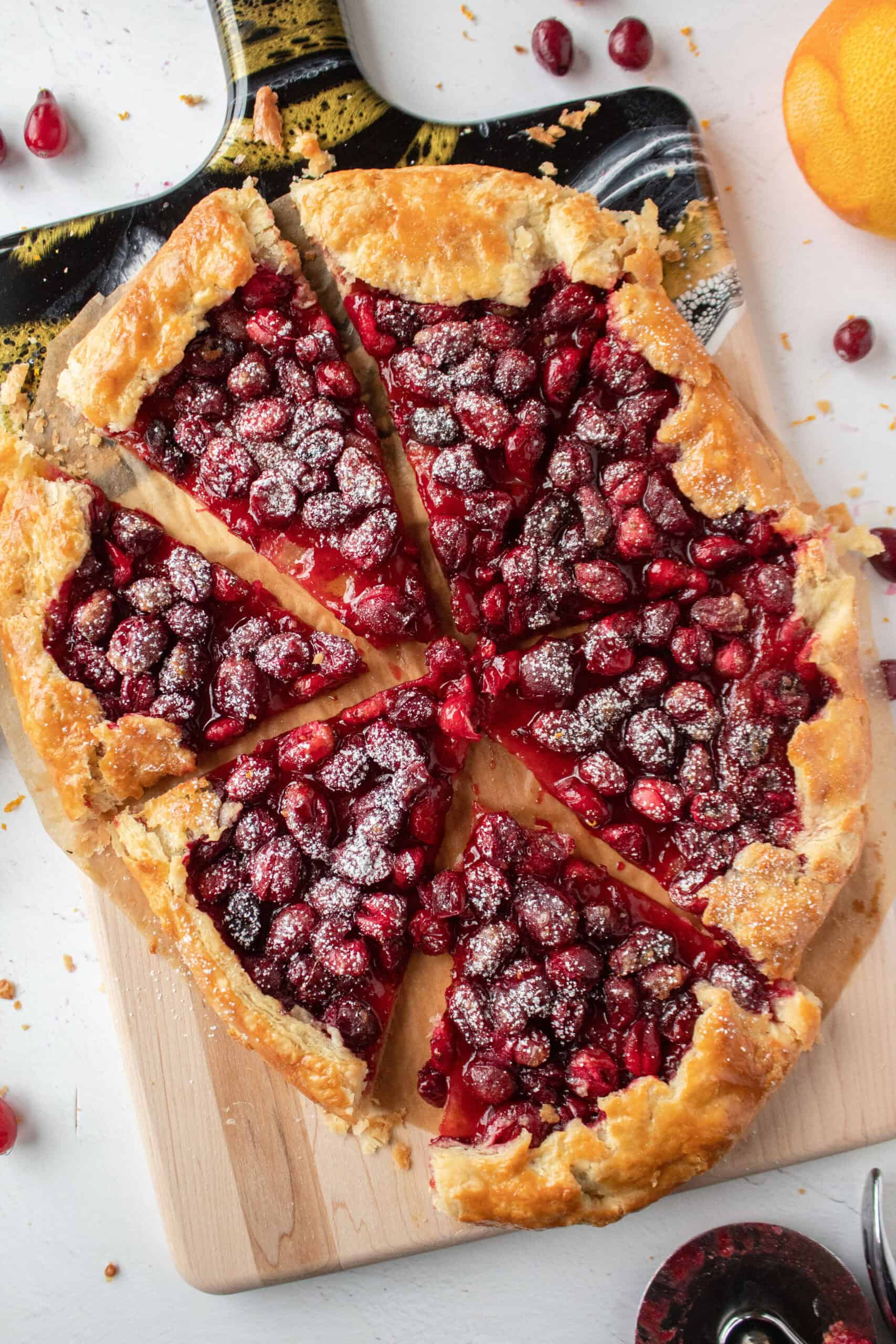 A sliced cranberry orange galette on a serving board.
