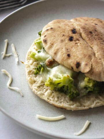 Broccoli pita melt on a sandwich with a close up of crispy bread and cheese.