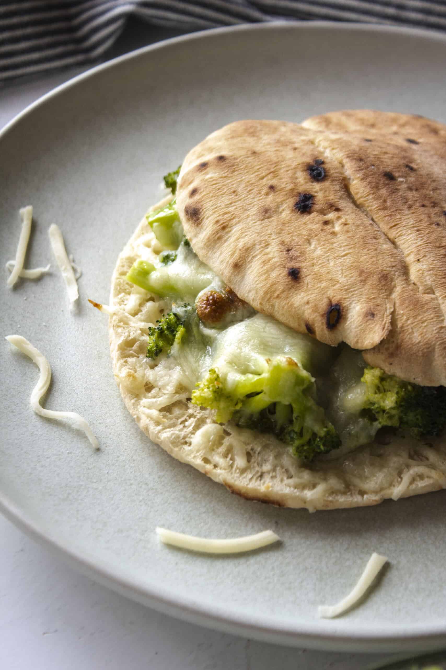 Broccoli pita melt on a sandwich with a close up of crispy bread and cheese.
