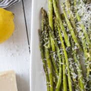 A platter of air fried asparagus topped with parmesan cheese and lemon zest.